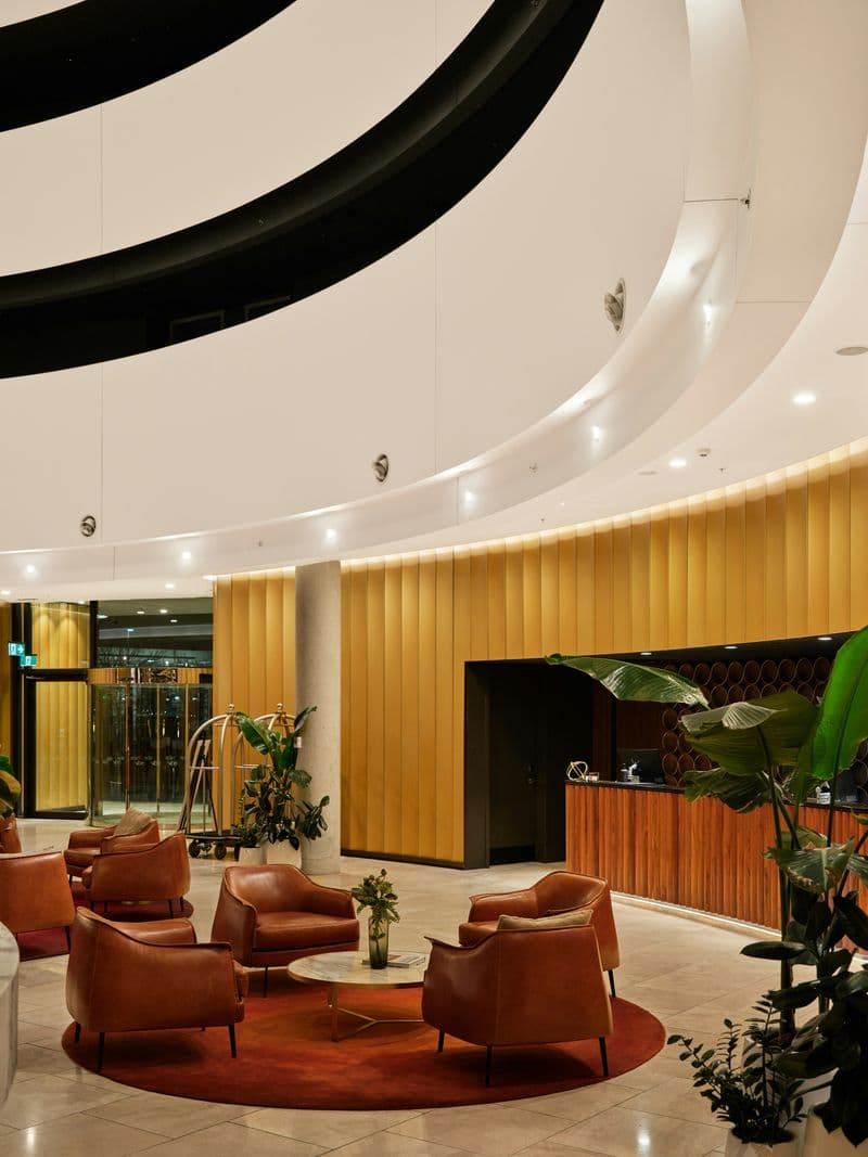 Modern business hotel lobby with leather seating area and reception desk